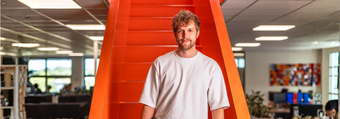 Jongen komt van oranje trap in kantoorruimte