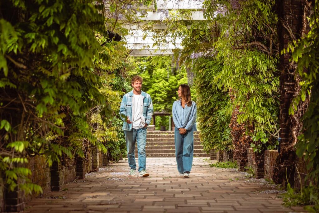 Collega's lachen naar elkaar en maken een wandeling in het park.