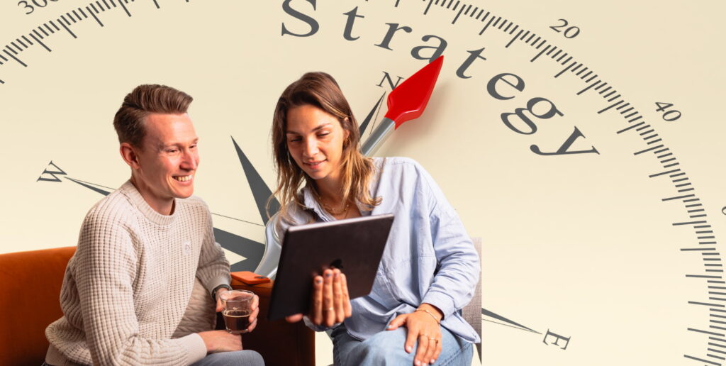 Twee collega's met en tablet kiezen een strategie, het woord staat ook op de achtergrond.